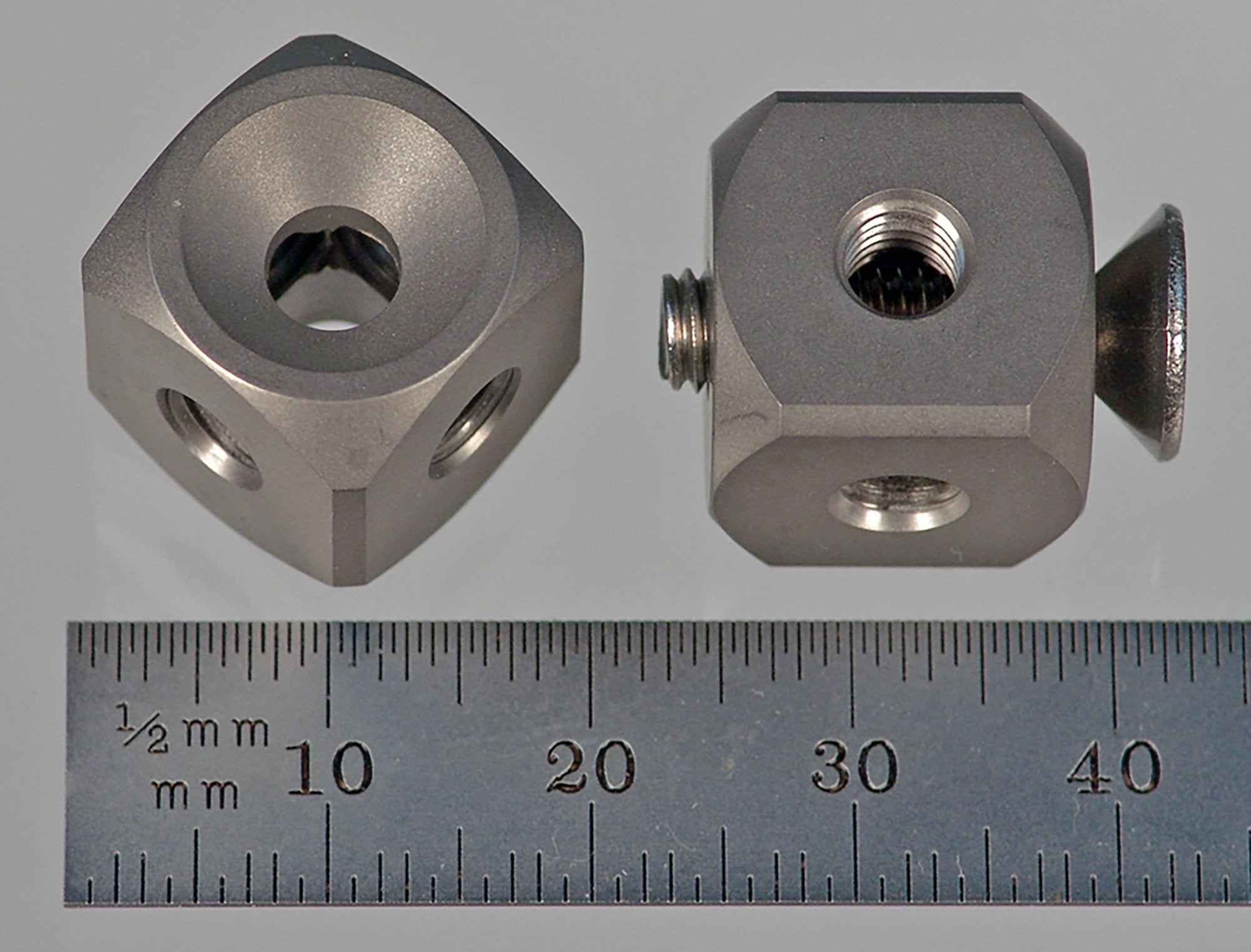 WM5-15-T-C M5 cube, six-sided, titanium, with a countersunk stainless steel flat head M5 hex screw.
